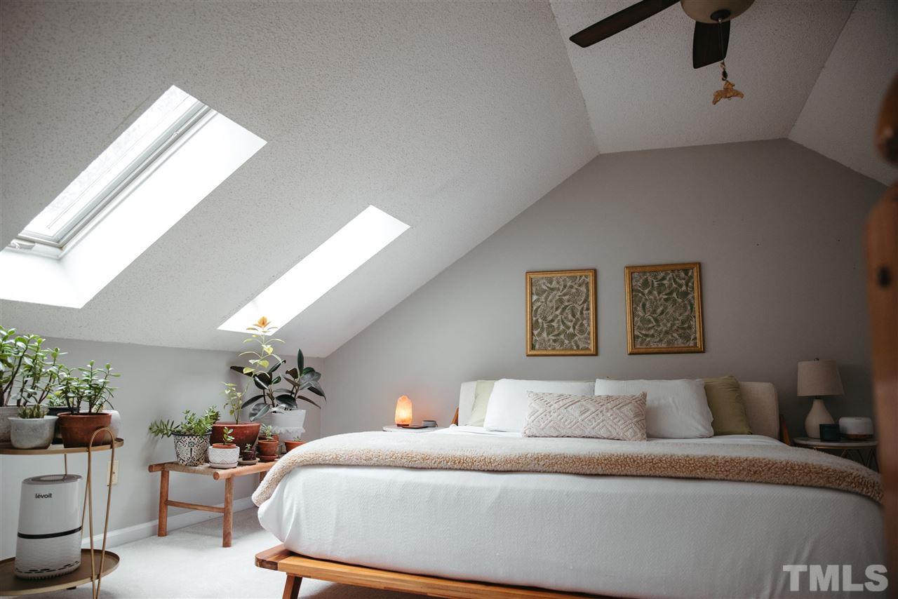 7020 Epping Forest Drive Raleigh, NC 27613 - Photo 22 of 29 a bedroom with a bed and a potted plant