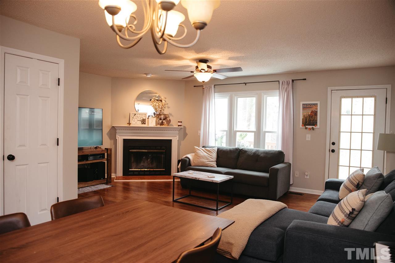 7020 Epping Forest Drive Raleigh, NC 27613 - Photo 7 of 29 a living room with furniture a fireplace and a large window