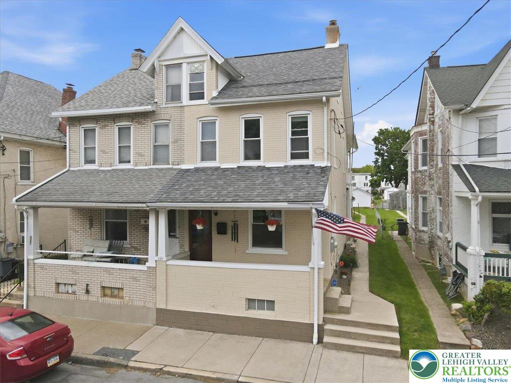 This classic two-story home features a welcoming covered porch, perfect for enjoying quiet mornings or evenings.