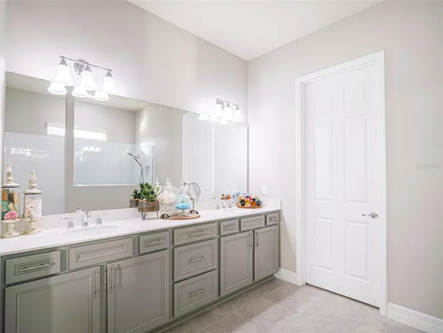 a bathroom with a double vanity sink and a mirror