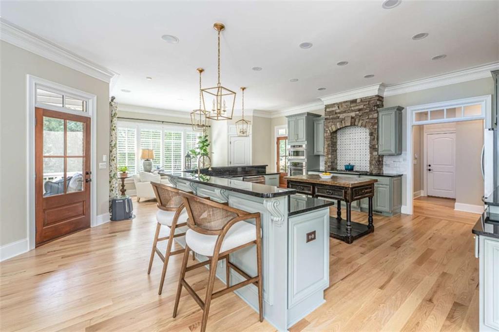 138 Nelson Boulevard Northwest Rome, GA 30165 - Photo 9 of 39 a kitchen with stainless steel appliances kitchen island granite countertop a stove a refrigerator and a dining table with wooden floor