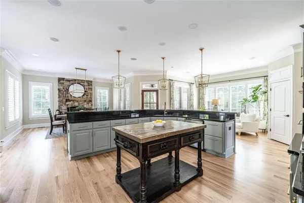 a room with lots of wooden furniture a chandelier and wooden floor