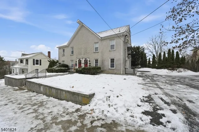 a view of the house with snow on the road