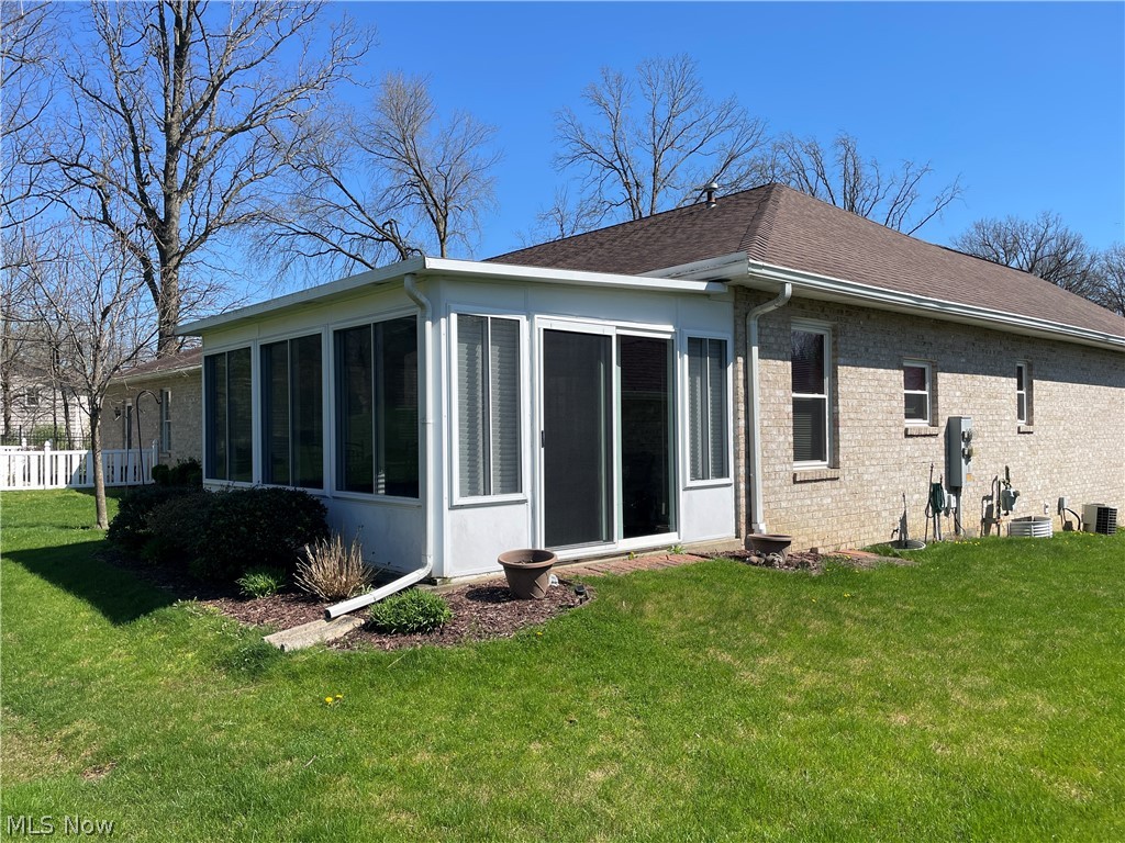 185 Mathews Road Youngstown, OH 44512 - Photo 2 of 29 Rear view of property with central air condition unit, a sunroom, and a lawn