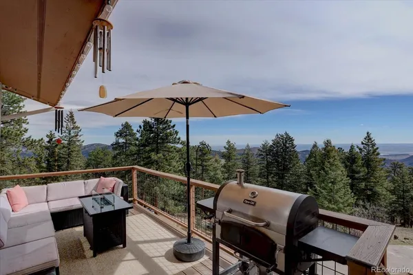 a view of a roof deck with couches and wooden fence