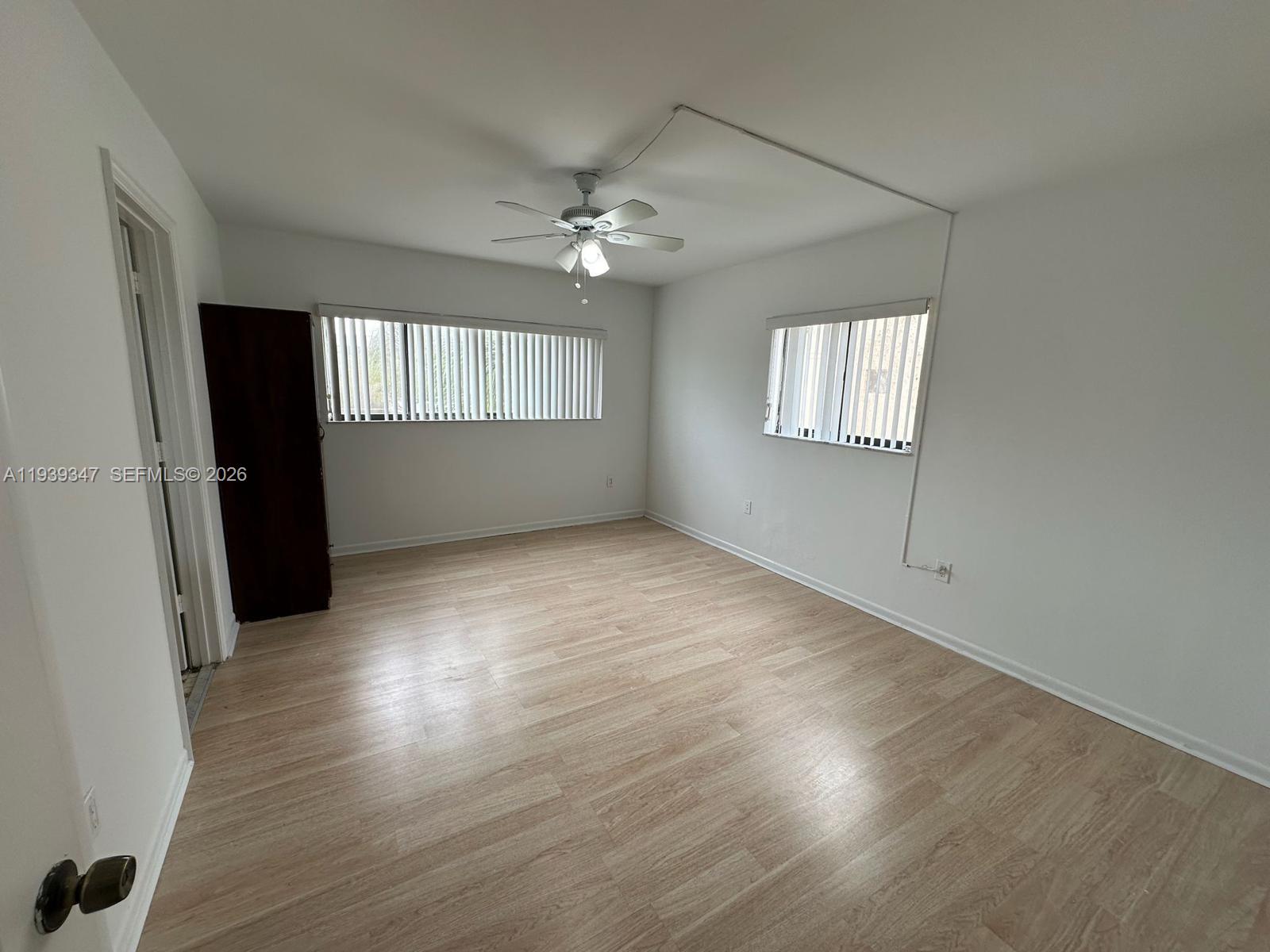 8540 Southwest 133rd Avenue Road, Unit 312 Miami, FL 33183 - Photo 13 of 15 an empty room with wooden floor and windows