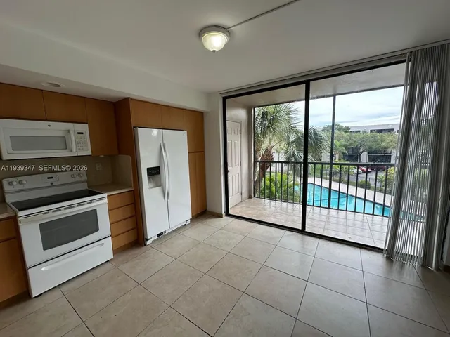 a view of a kitchen with refrigerator and window