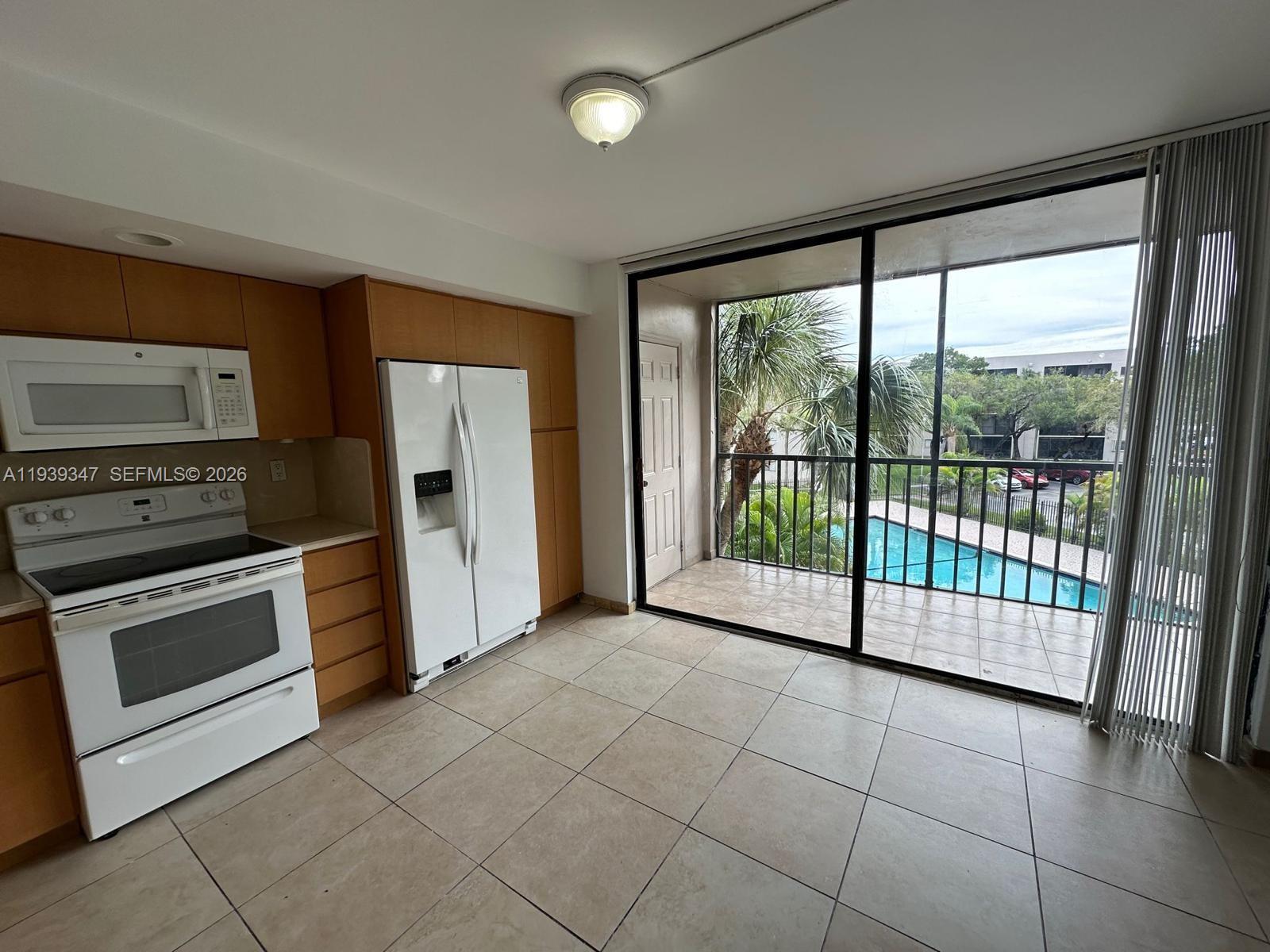 8540 Southwest 133rd Avenue Road, Unit 312 Miami, FL 33183 - Photo 2 of 15 a view of a kitchen with refrigerator and window