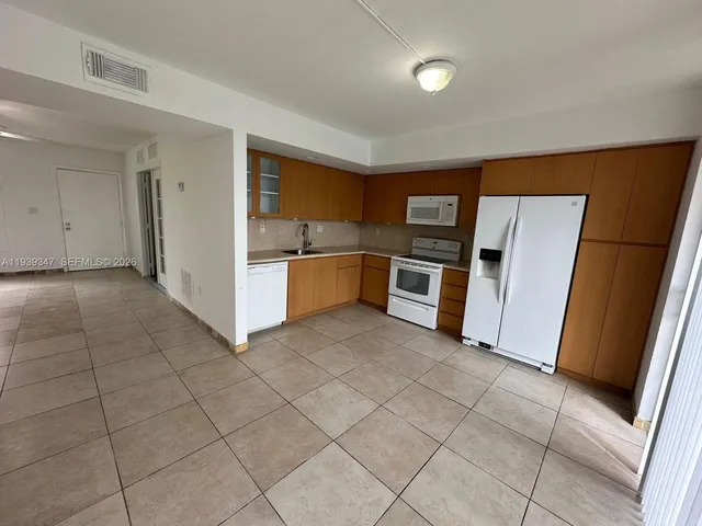 a kitchen with granite countertop a refrigerator and a stove top oven