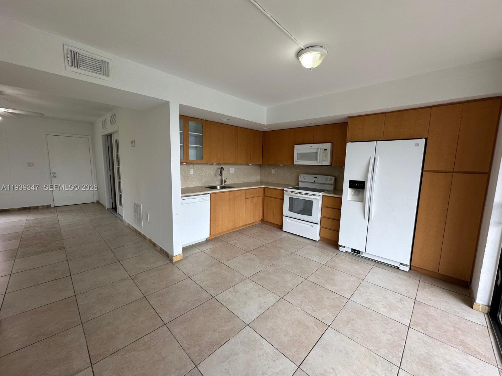 8540 Southwest 133rd Avenue Road, Unit 312 Miami, FL 33183 - Photo 5 of 15 a kitchen with stainless steel appliances a refrigerator and a stove