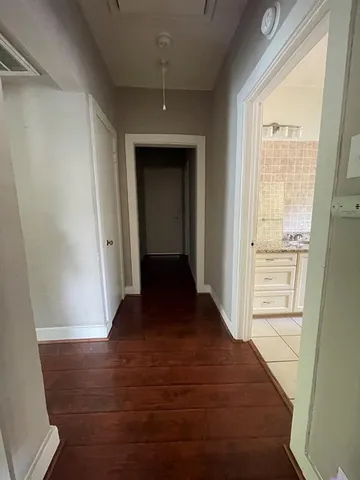 a view of a hallway with wooden floor and closet