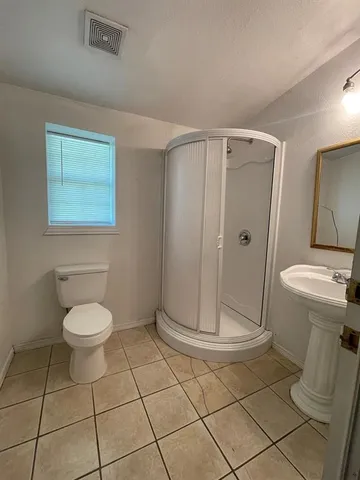 a bathroom with a toilet and a shower