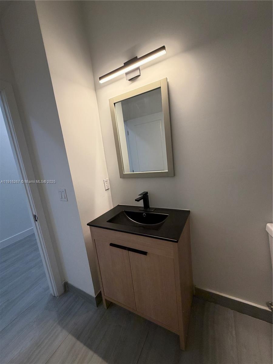932 Southwest 10th Street, Unit 3 Hallandale Beach, FL 33009 - Photo 13 of 22 a bathroom with a granite countertop sink and a mirror