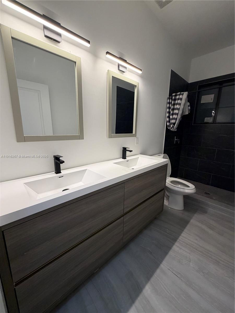 932 Southwest 10th Street, Unit 3 Hallandale Beach, FL 33009 - Photo 15 of 22 a bathroom with a double vanity sink and a mirror