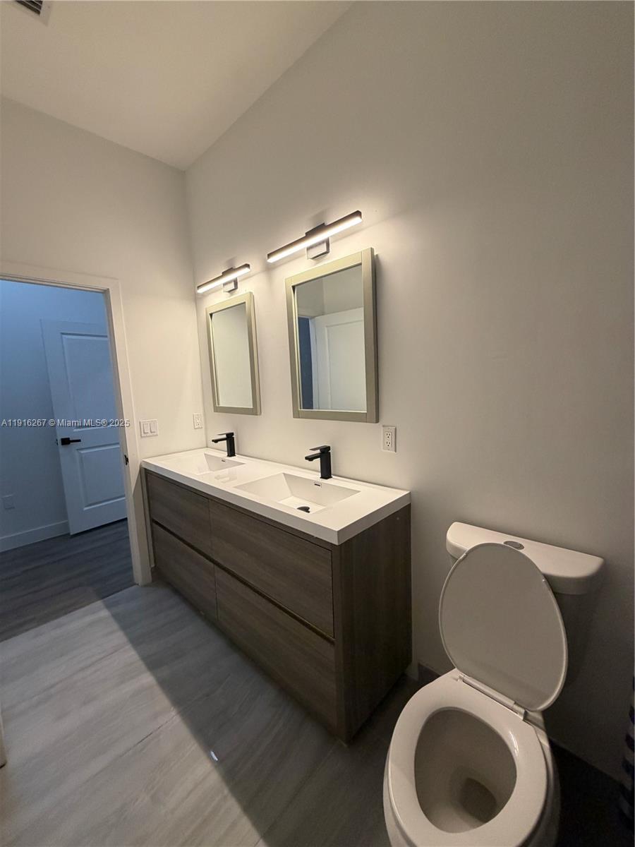 932 Southwest 10th Street, Unit 3 Hallandale Beach, FL 33009 - Photo 17 of 22 a bathroom with a toilet sink and mirror
