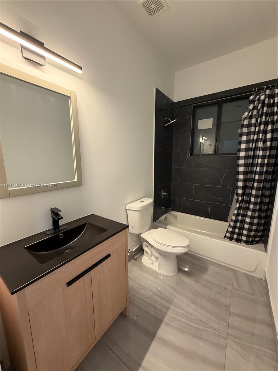 932 Southwest 10th Street, Unit 3 Hallandale Beach, FL 33009 - Photo 19 of 22 a bathroom with a sink a toilet and shower