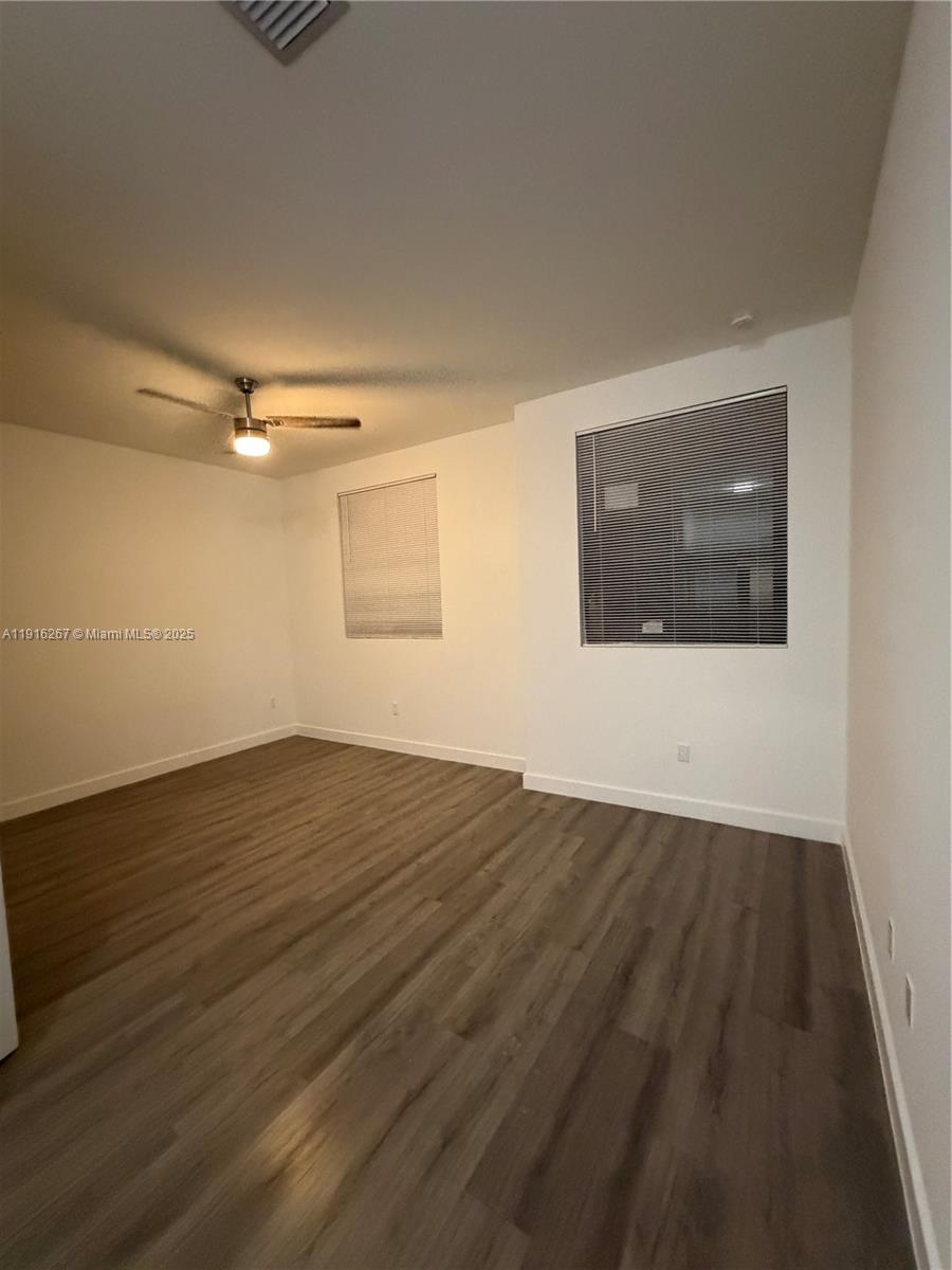 932 Southwest 10th Street, Unit 3 Hallandale Beach, FL 33009 - Photo 6 of 22 a view of an empty room with wooden floor and a window