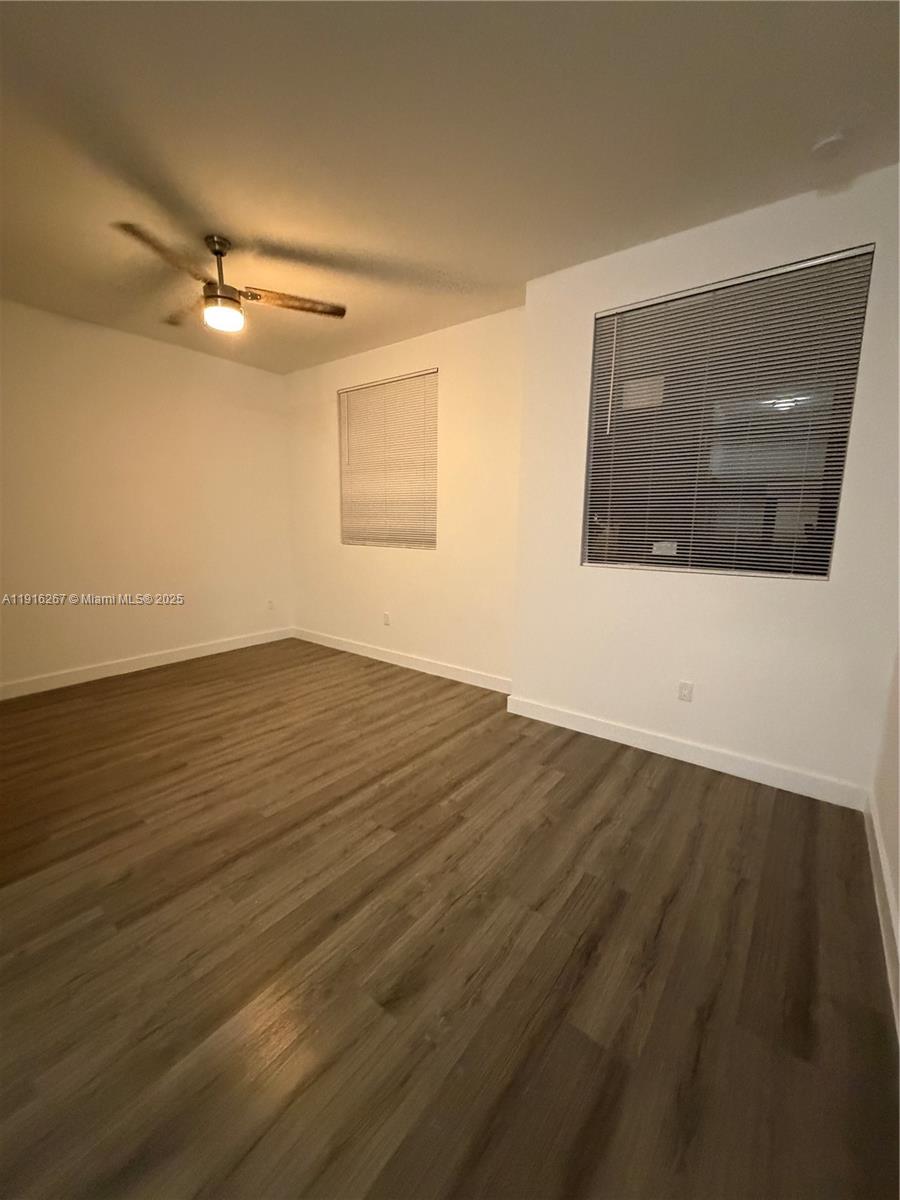 932 Southwest 10th Street, Unit 3 Hallandale Beach, FL 33009 - Photo 8 of 22 an empty room with wooden floor and windows
