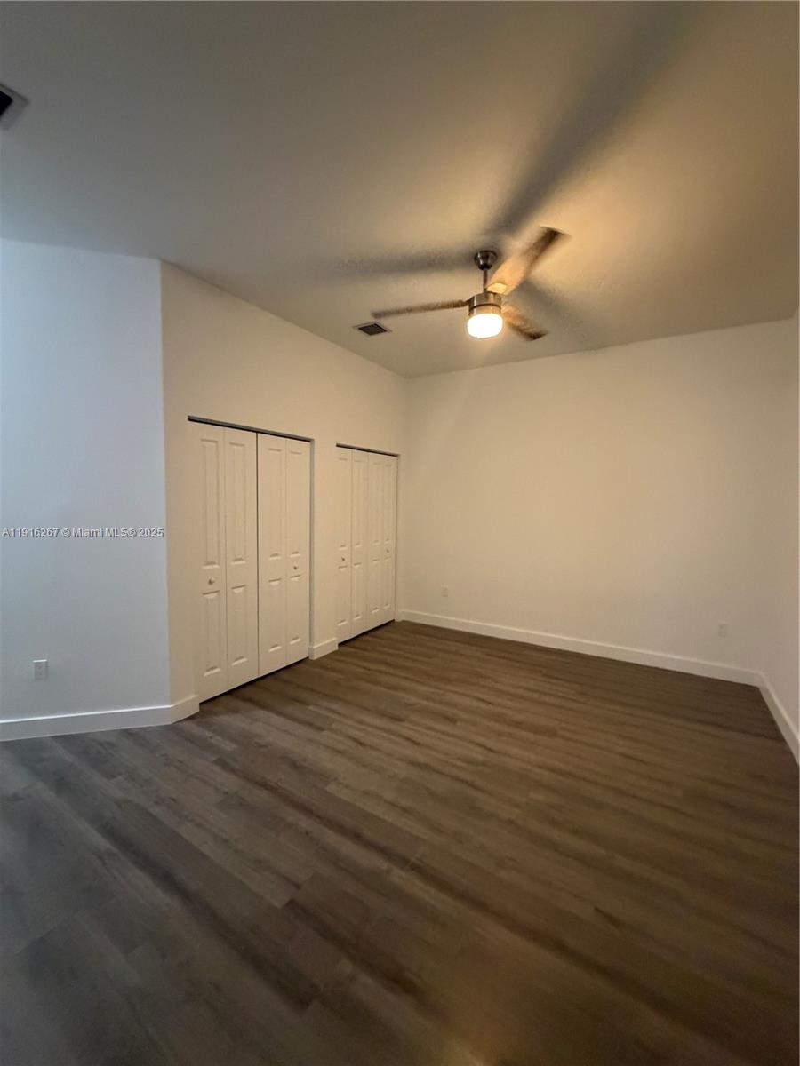932 Southwest 10th Street, Unit 3 Hallandale Beach, FL 33009 - Photo 9 of 22 an empty room with wooden floor fan and windows