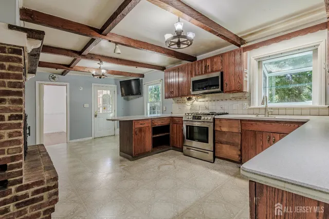 a large kitchen with stainless steel appliances granite countertop a stove and a sink