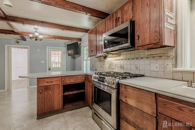 a kitchen with stainless steel appliances granite countertop wooden cabinets and a stove top oven