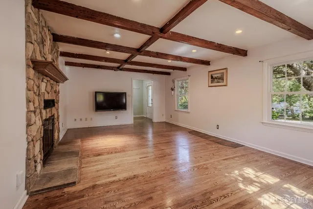 a view of a livingroom with wooden floor and a ceiling fan