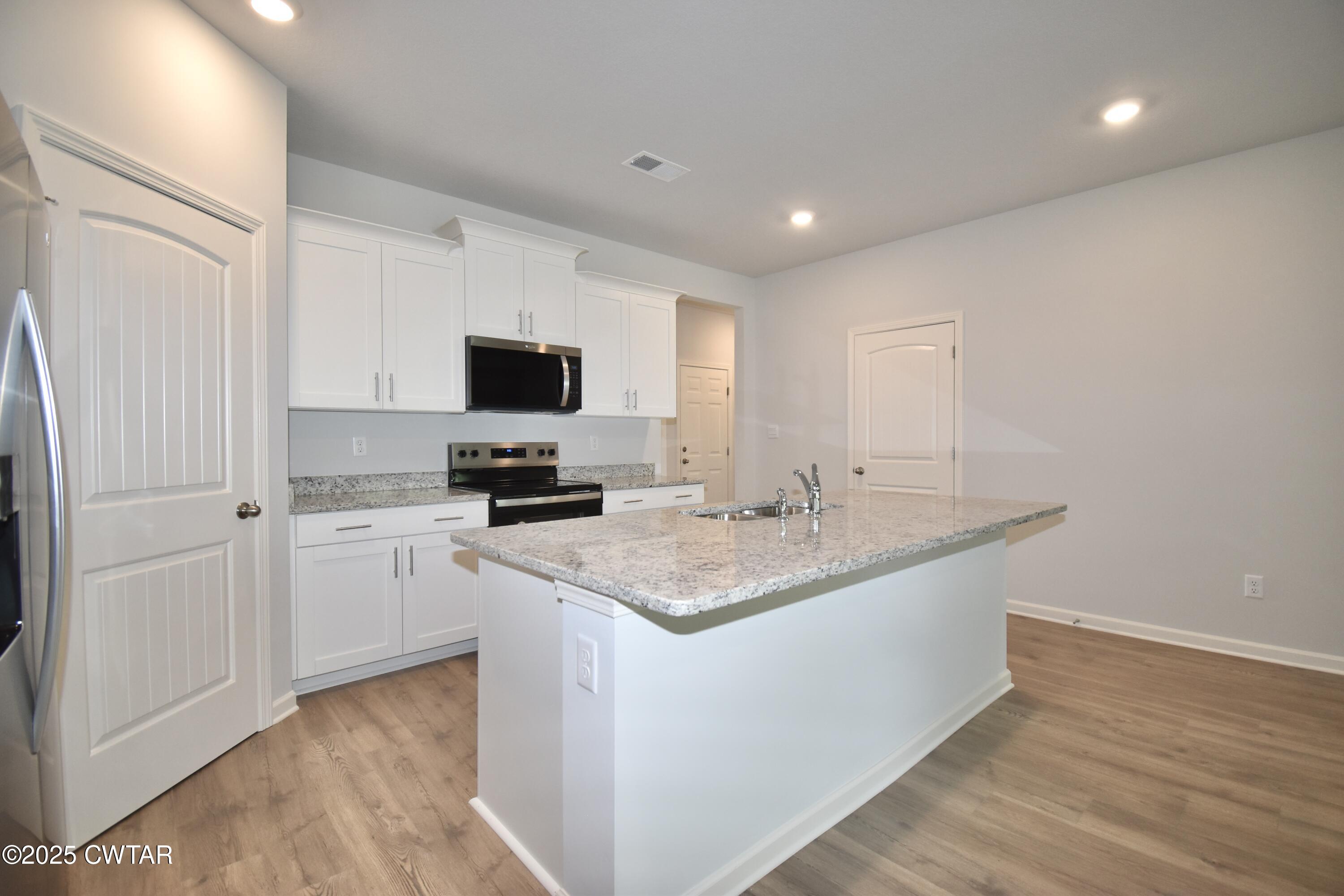 44 Clarendon Cove Jackson, TN 38305 - Photo 5 of 17 a kitchen with stainless steel appliances granite countertop a stove a sink and a refrigerator