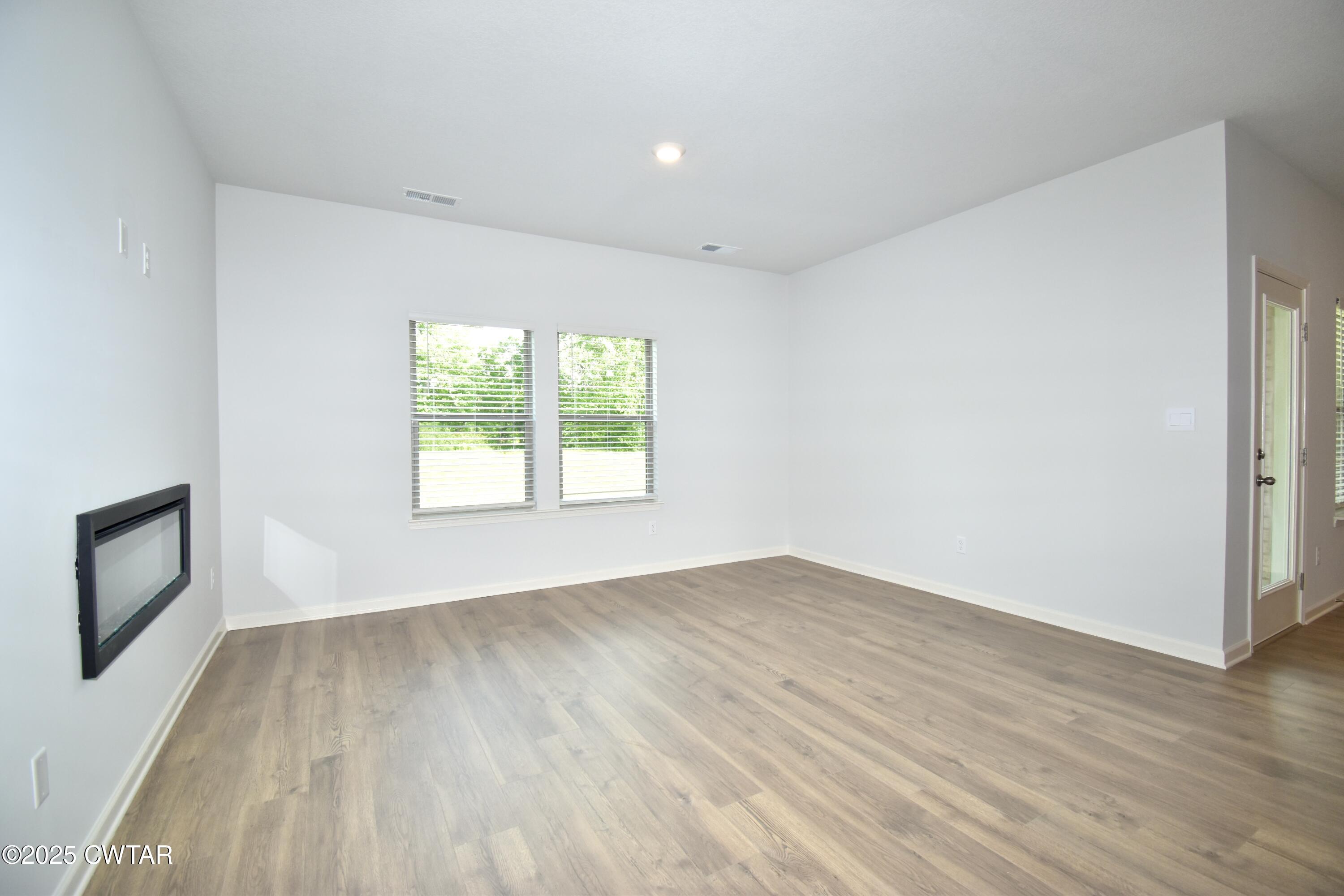 44 Clarendon Cove Jackson, TN 38305 - Photo 7 of 17 an empty room with wooden floor and windows