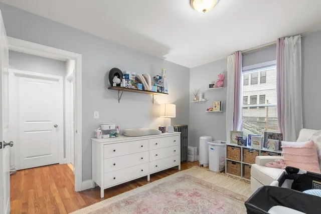 a bedroom with a baby bed couch and a window