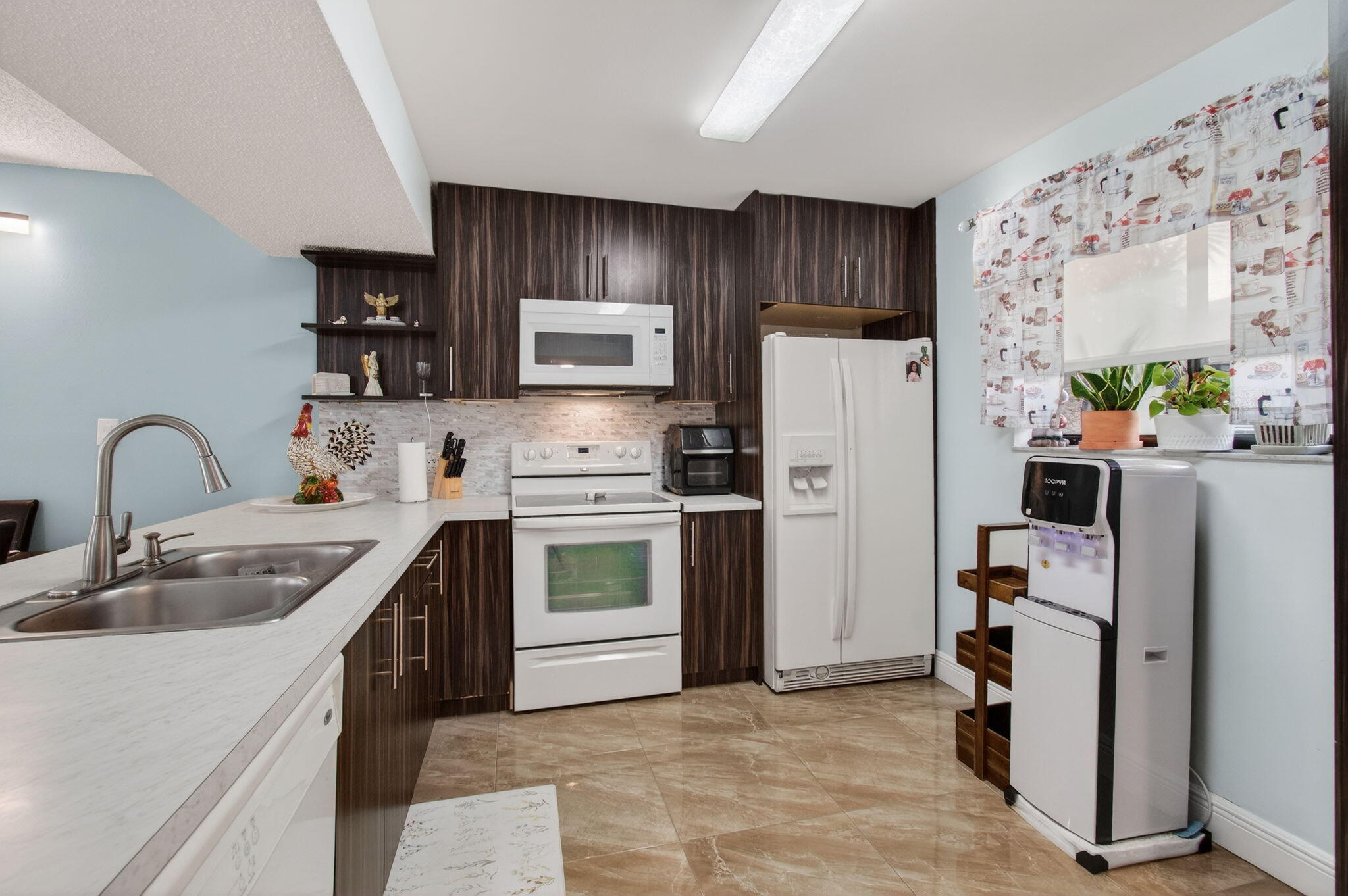 5220 Las Verdes Circle, Unit 322 Delray Beach, FL 33484 - Photo 21 of 65 a kitchen with stainless steel appliances a refrigerator sink and microwave