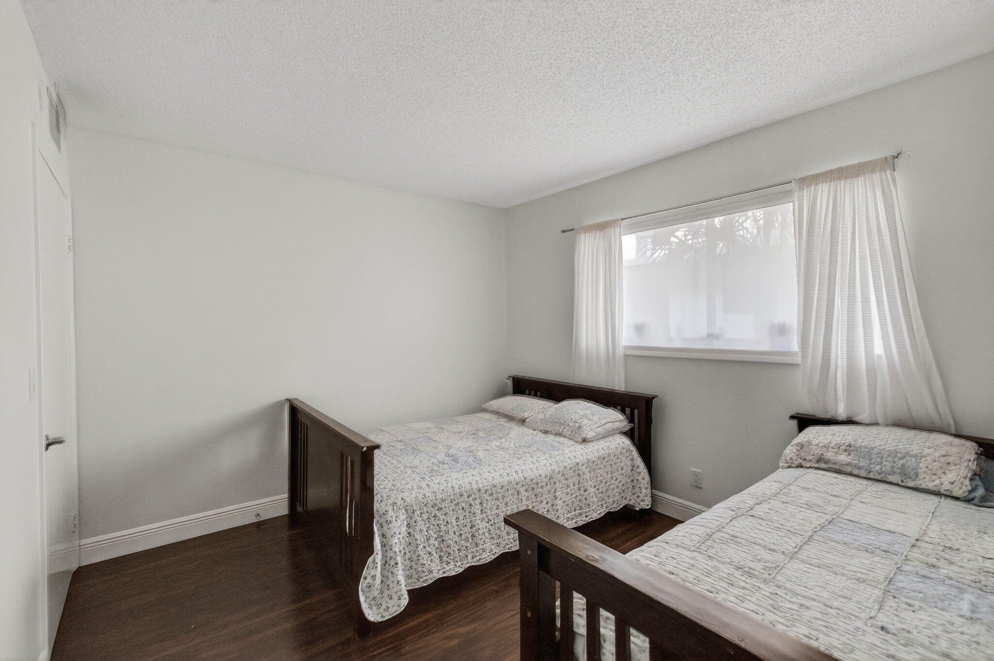 5220 Las Verdes Circle, Unit 322 Delray Beach, FL 33484 - Photo 25 of 65 a bedroom with a bed and wooden floor