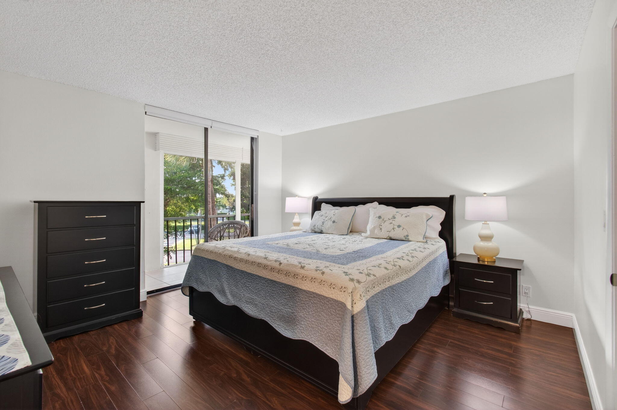 5220 Las Verdes Circle, Unit 322 Delray Beach, FL 33484 - Photo 29 of 65 a bedroom with a bed and a dresser