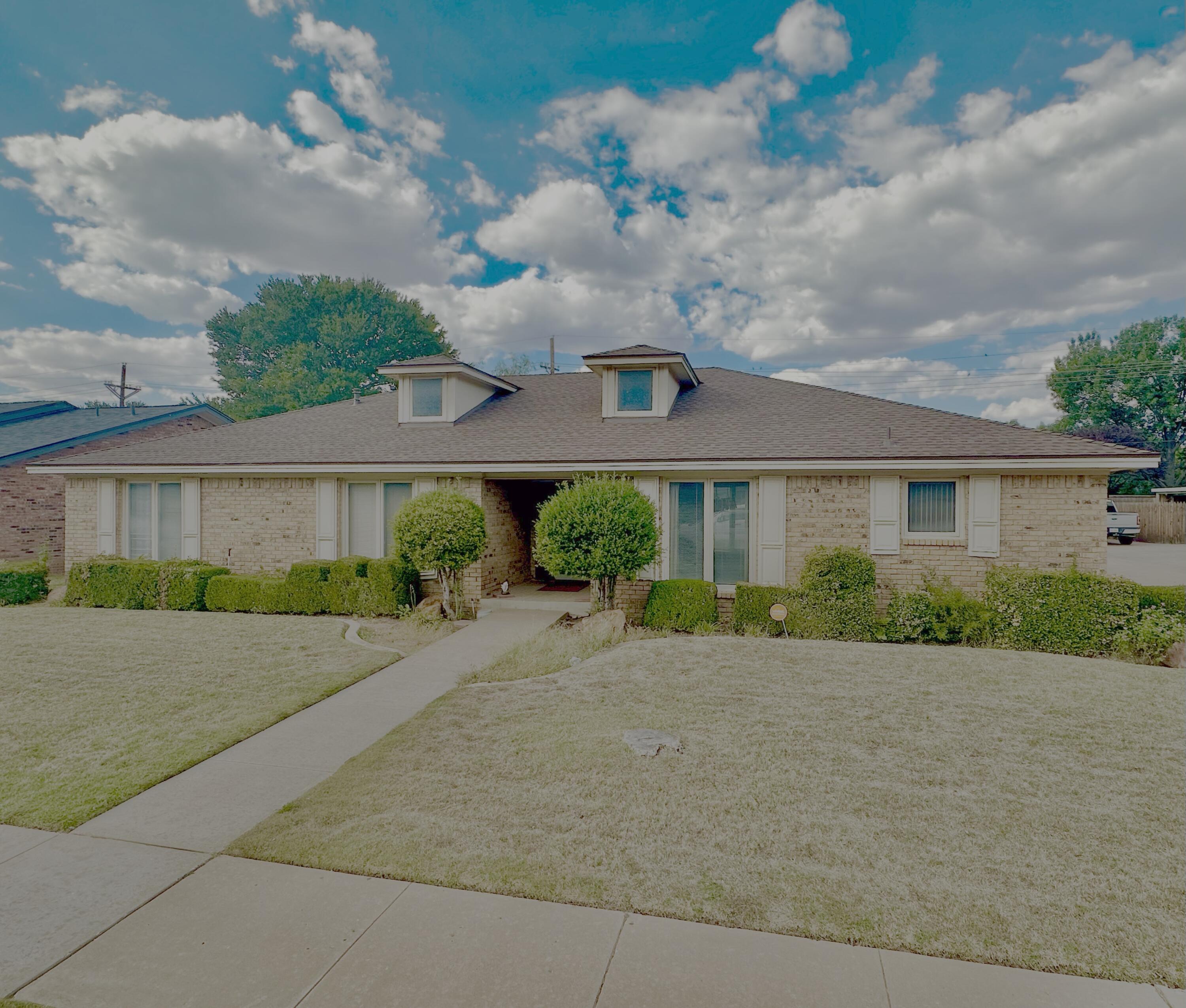 4610 88th Street Lubbock, TX 79424 - Photo 2 of 20 a front view of a house with a yard and potted plants