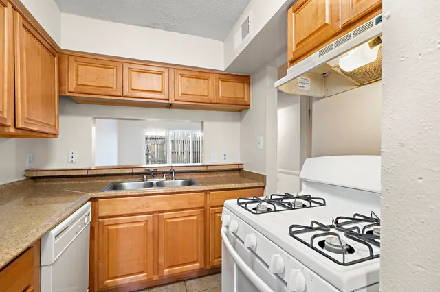 a kitchen with stainless steel appliances granite countertop a stove and a sink