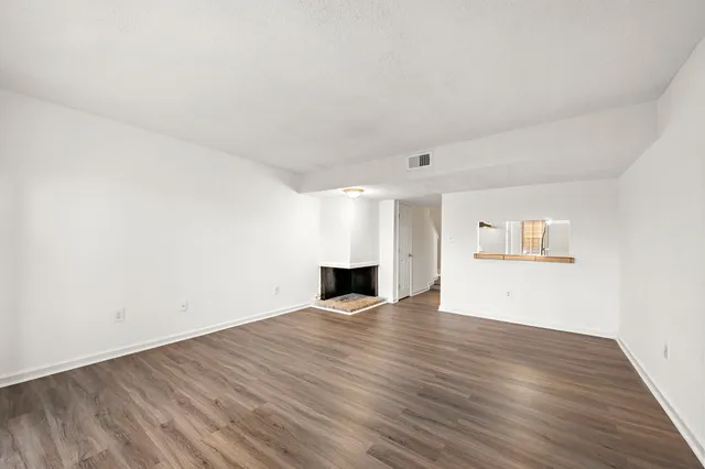 a view of empty room with wooden floor and window
