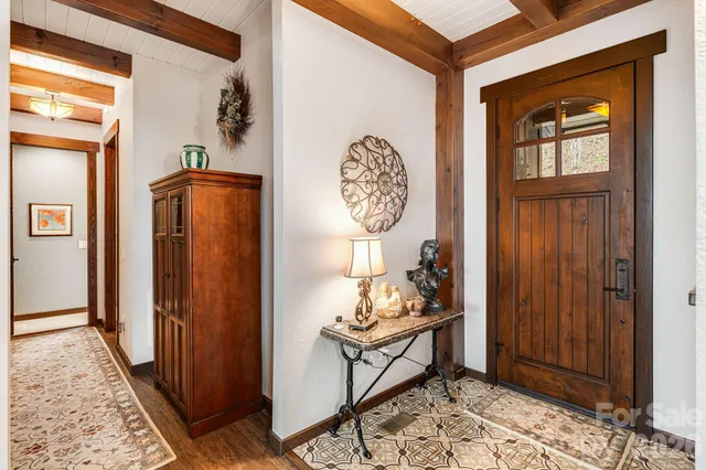 a view of a hallway with wooden floor and a window