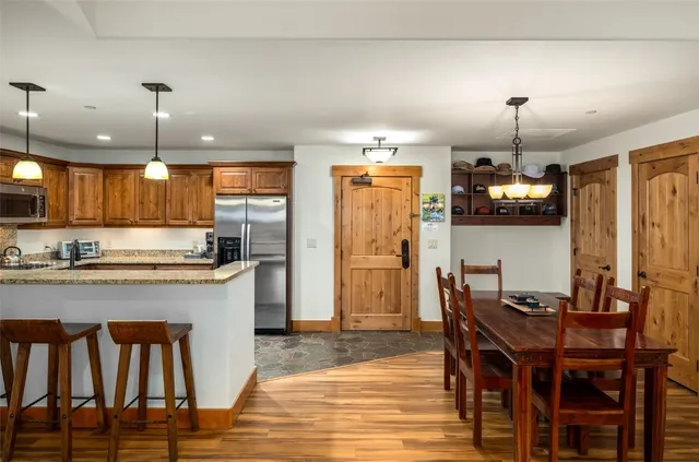 a kitchen with refrigerator and chairs