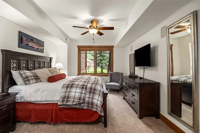 a bedroom with a bed and a flat tv screen on dresser