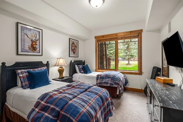 a bedroom with two beds and a flat screen tv