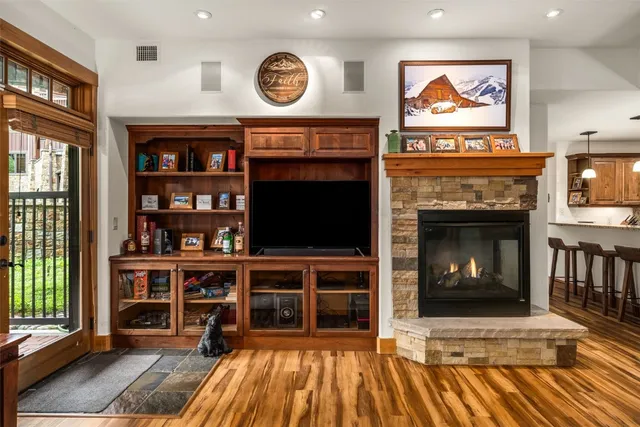 a view of front door with wooden floor and a fireplace