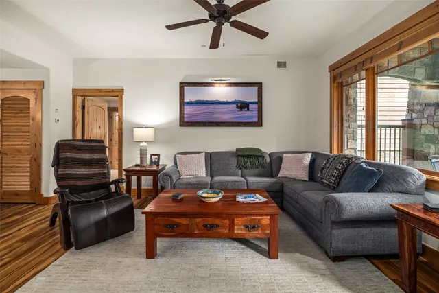 a living room with furniture a ceiling fan and a window