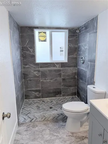 a bathroom with a toilet and a shower