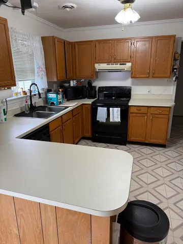 a kitchen with granite countertop a sink a counter space and cabinets