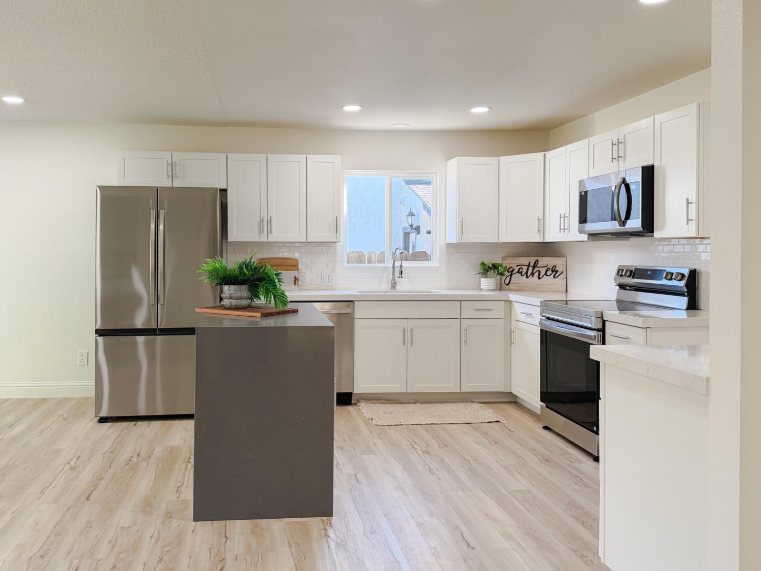 878 Carol Avenue Merced, CA 95341 - Photo 12 of 41 a kitchen with stainless steel appliances a refrigerator sink and white cabinets