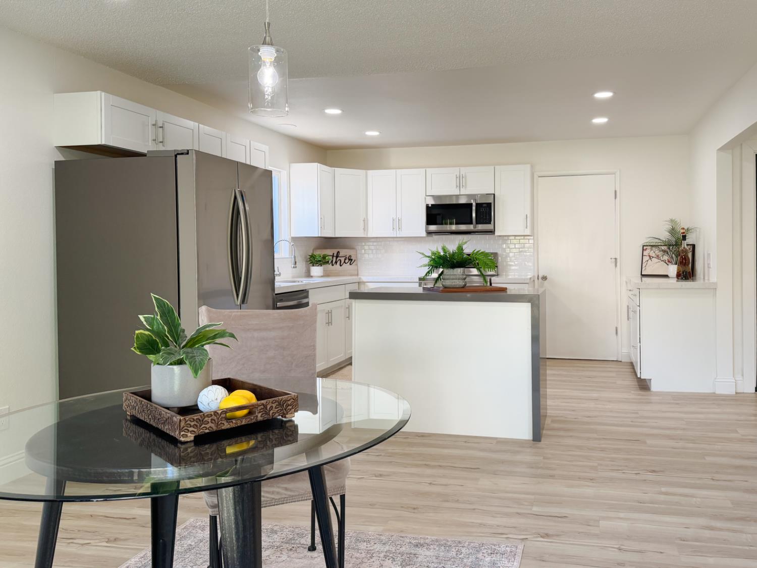 878 Carol Avenue Merced, CA 95341 - Photo 15 of 41 a kitchen with a table potted plant and refrigerator