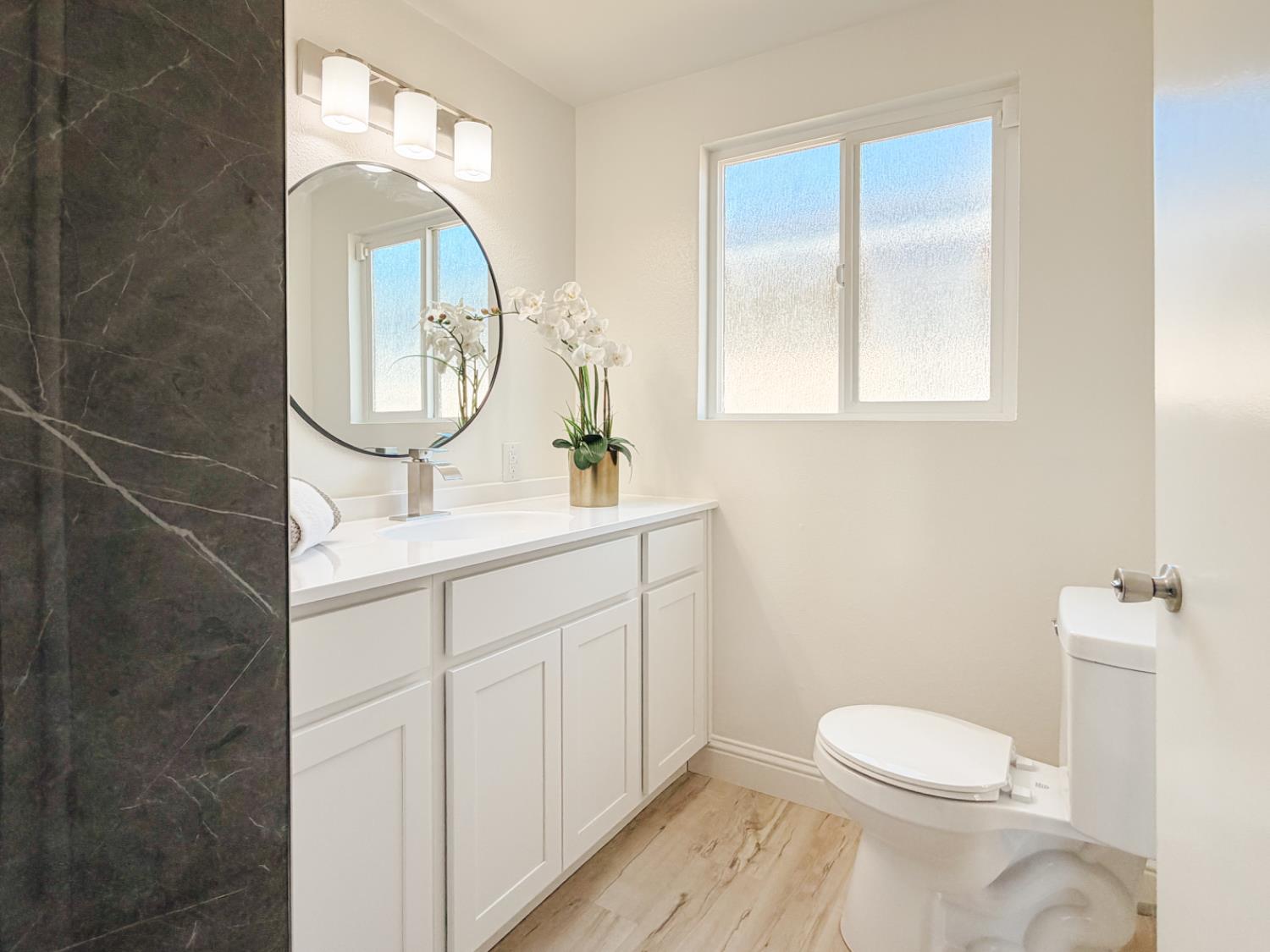 878 Carol Avenue Merced, CA 95341 - Photo 30 of 41 a bathroom with a toilet a sink a mirror and vanity