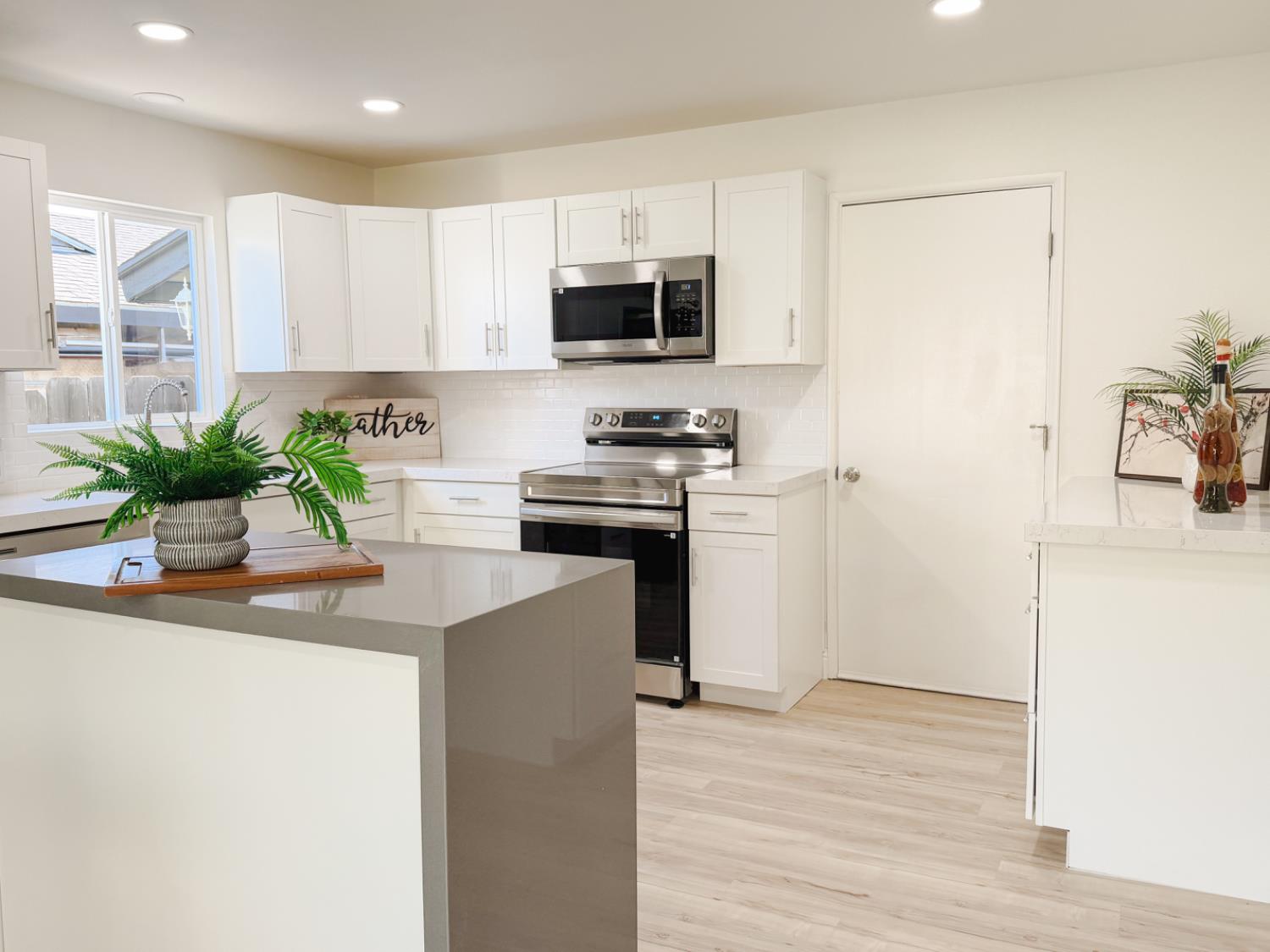 878 Carol Avenue Merced, CA 95341 - Photo 10 of 41 a kitchen with granite countertop a stove a sink and a microwave