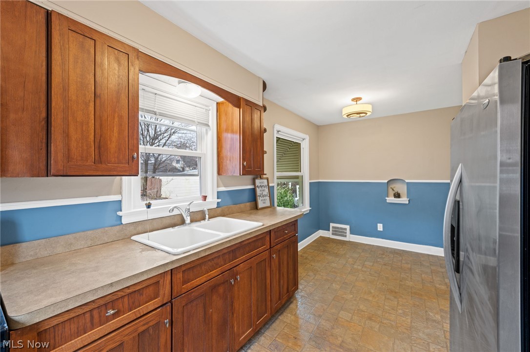 2513 Ralph Avenue Cleveland, OH 44109 - Photo 7 of 14 Kitchen with stainless steel fridge, light tile flooring, and sink