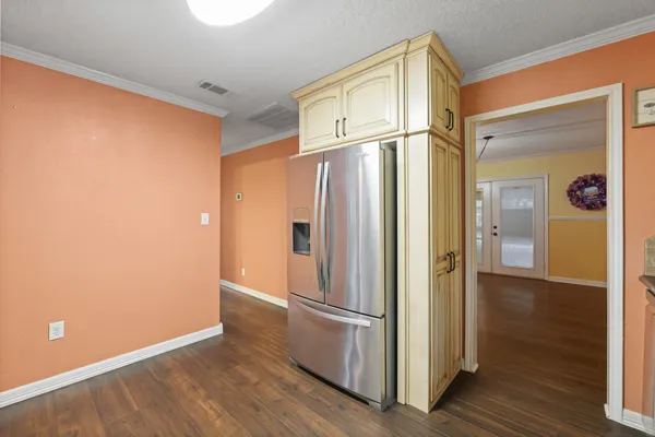 a view of a refrigerator in kitchen and wooden floor