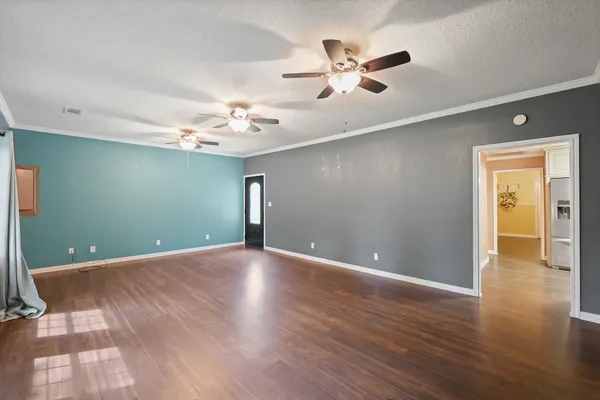 a view of an empty room with wooden floor